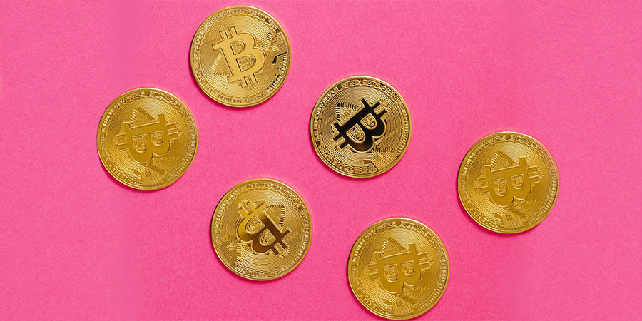 six pieces of gold bitcoins and a pink background